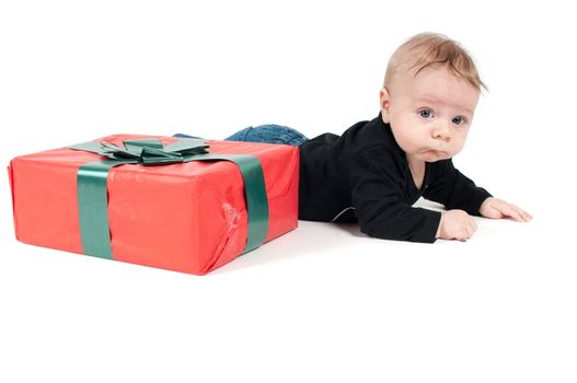 Beautiful baby boy with christmas present on white