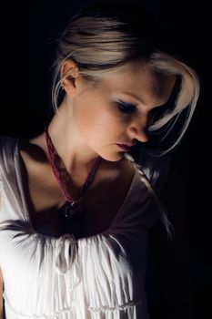 A beautiful blonde girl against a dark background