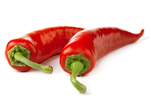 Two red chili peppers isolated on a white background