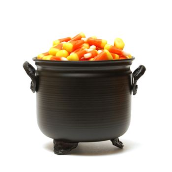 A black cauldron is filled with candy corn for the trick or treat holiday.