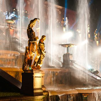 Sculptures with fountain on background at night at Petergof, Russia