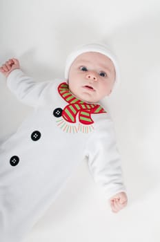 Baby boy in snowman costume on light background