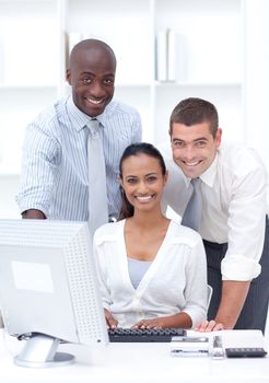 Businessmen and businesswoman using a laptop in office