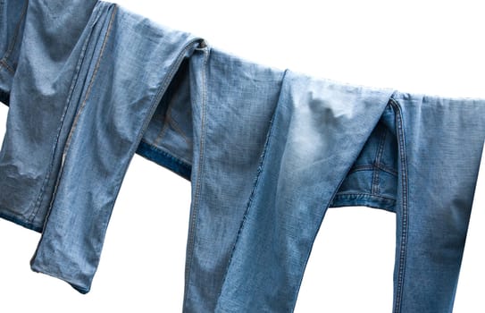 Jeans on a clothesline to dry on white background.