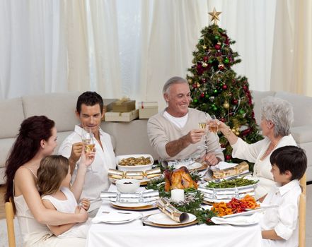 Grandparents and parents tusting in a Christmas dinner at home