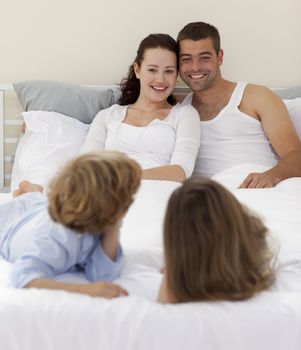 Brothers and parents lying together in bed