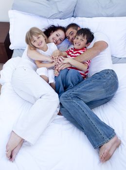 High view of parents and children relaxing in bed together