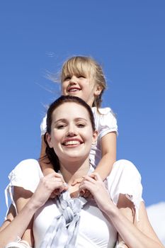 High angle of mother giving her daughter piggyback ride outdoors