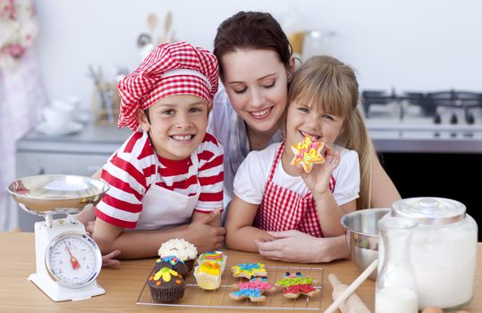 Smiling young mother and children baking in the kitchen