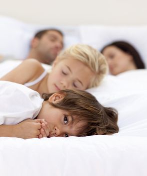 Little boy relaxing with his parents and sister sleeping