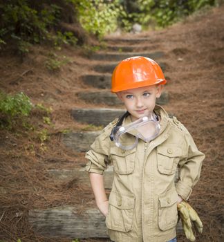 Happy Adorable Child Boy with Big Gloves, Hard Hat and Goggles Playing Handyman Outside.