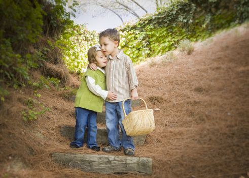 Adorable Brother and Sister Children with Basket Hugging Outside.