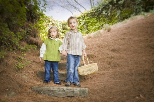 Adorable Brother and Sister Children Holding Hands Walking Down Wood Steps with Basket Outside.