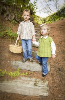 Adorable Brother and Sister Children Holding Hands Walking Down Wood Steps with Basket Outside.