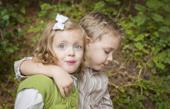 Adorable Brother and Sister Children Hugging Each Other Outside.