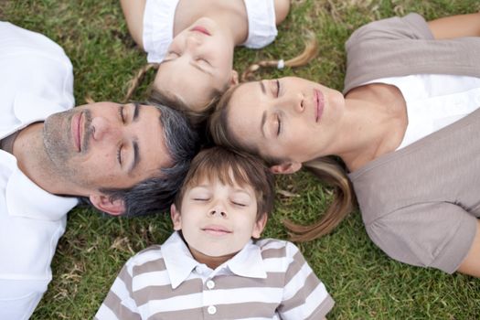 Parents and children sleeping outdoors with heads together