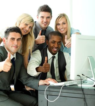 Young business team working in office with thumbs up