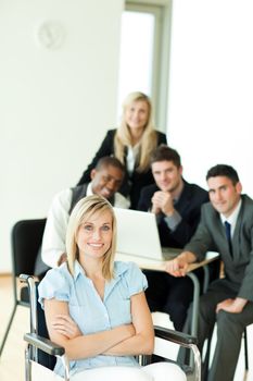 Smiling businesswoman with her group working in the background