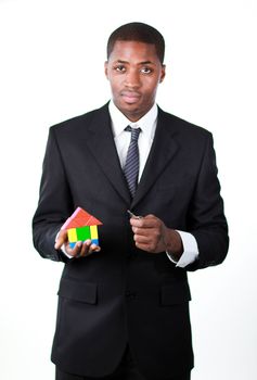 Confident businessman with a house for an real estate concept and looking seriously at the camera