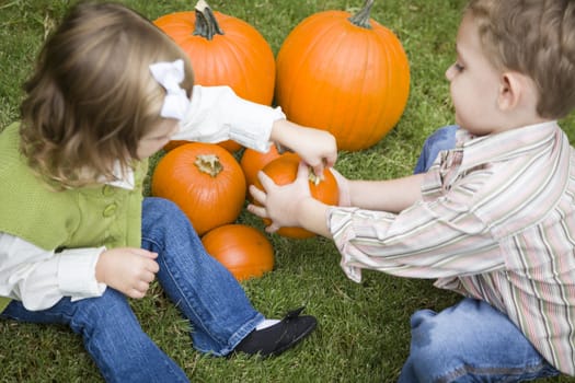 Cute Young Brother and Sister Children Enjoying the Pumpkins at the Pumpkin Patch.