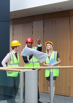 Young architects studying a building with some plans