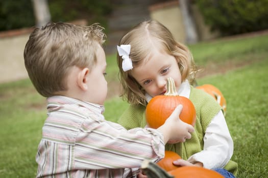 Cute Young Brother and Sister Children Enjoying the Pumpkins at the Pumpkin Patch.