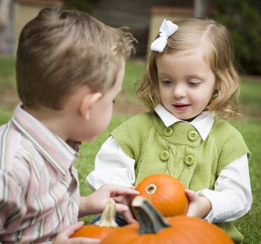 Cute Young Brother and Sister Children Enjoying the Pumpkins at the Pumpkin Patch.