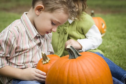 Cute Young Brother and Sister Children Enjoying the Pumpkins at the Pumpkin Patch.