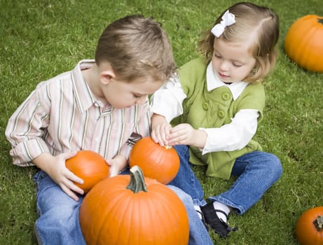 Cute Young Brother and Sister Children Enjoying the Pumpkins at the Pumpkin Patch.