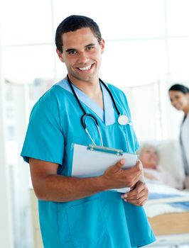 Attractive male doctor holding a medical clipboard in a hospital