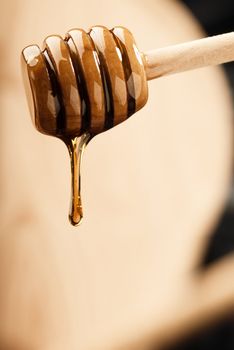 Dripping light honey from a wooden dripper