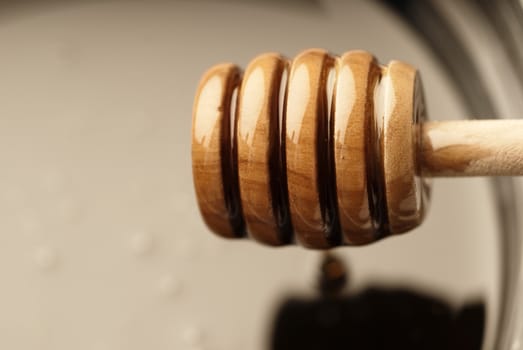 Closeup of a wooden honey stick dripping with nectar