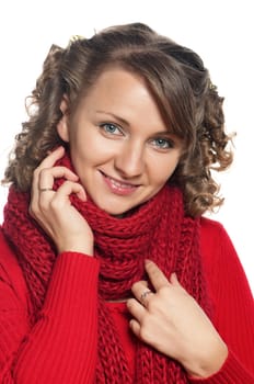 Portrait of a young woman in warm sweater and scarf with happy smile posing on white