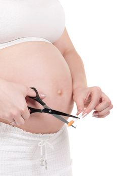 Pregnant belly with cigarettes - isolated over a white background. Third trimester.