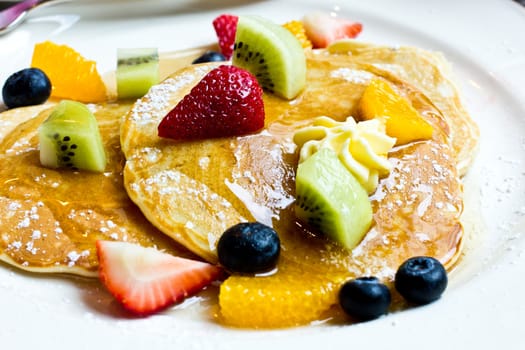 Delicious pancake with fresh stawberry, kiwi, orange, blueberry.