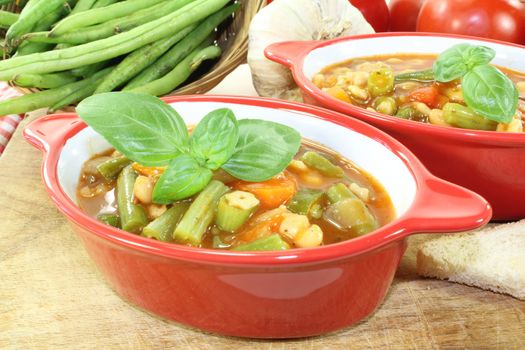 Minestrone with beans, carrots, potatoes and leeks on a light background