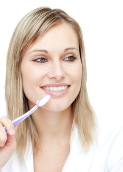 Radiant woman holding a toothbrush against a white background