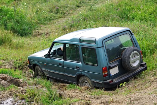 Green off-road jeep on a meadow