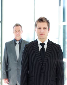 Confident young businessman standing in front of the camera