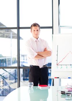 Attractive confident businessman with folded arms in a presentation