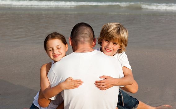 Father with his two children on the beach