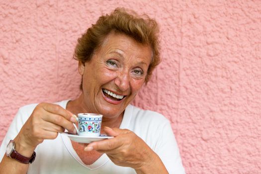Older lady drinking her Turkish Coffee and giving caffeinated look.