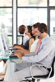 Young businessman working in a call center with his colleagues