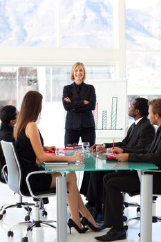 Attractive confident businesswoman smiling at the camera in a meeting