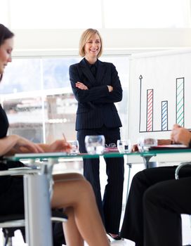 Attractive mature businesswoman smiling at her colleagues in a meeting