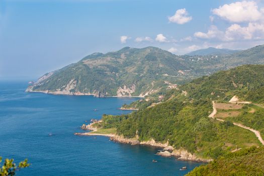 Scenic old dirt roads by the Black Sea between green foliage and blue sea.