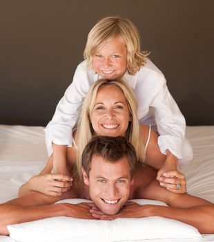 Smiling father, mother and son in a mountain in bed at home