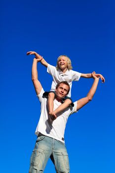 Man giving young boy piggyback ride outdoors smiling