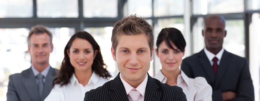 Smiling business manager standing in office leading his team 