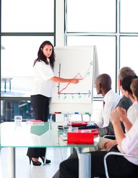 Brunette businesswoman reporting to sales figures to her team